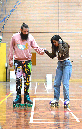 Person helping another rollerskate